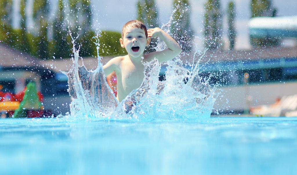 Little Boy Jumping Into the Pooling making a splash